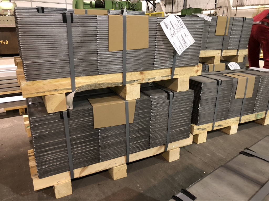 Strapped packages of shaped cut-to-size pieces on wooden pallets